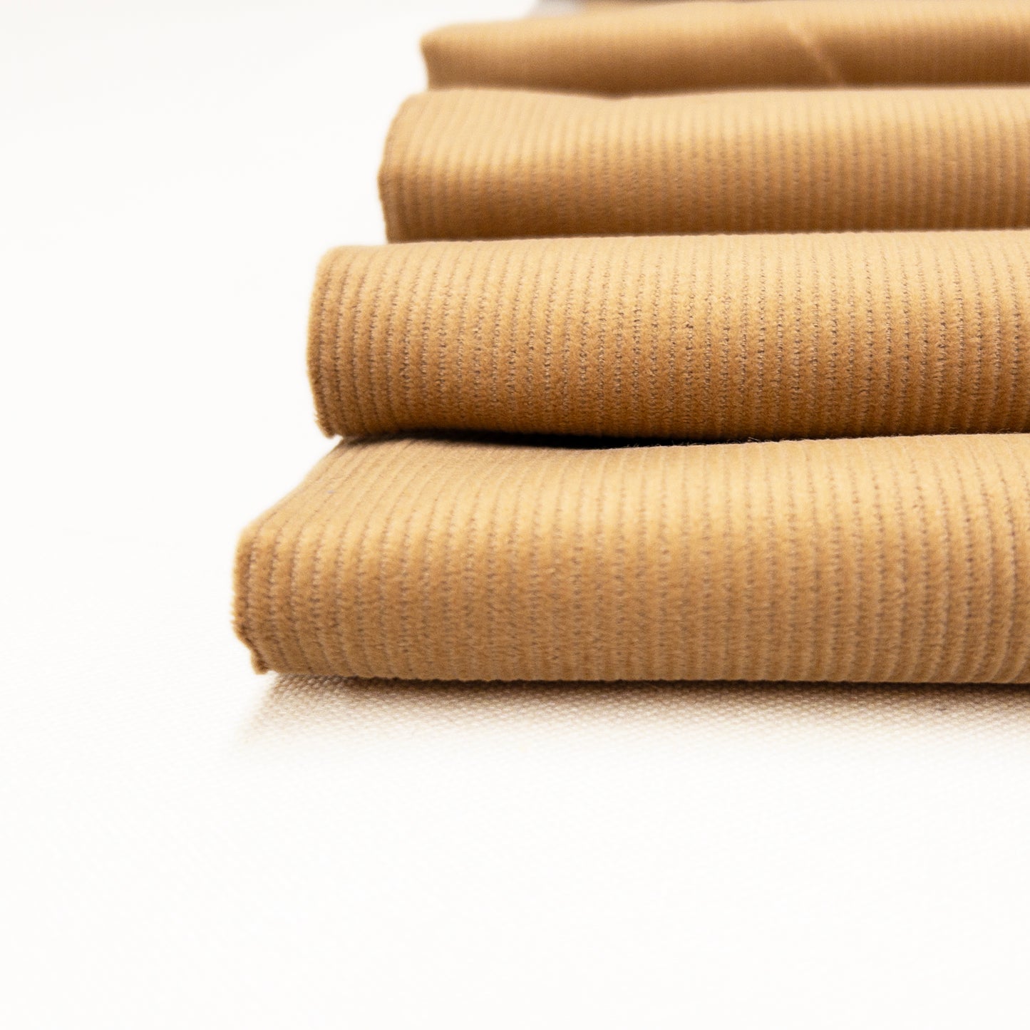 Close up view of 14 wale corduroy with a low cut pile in toast.