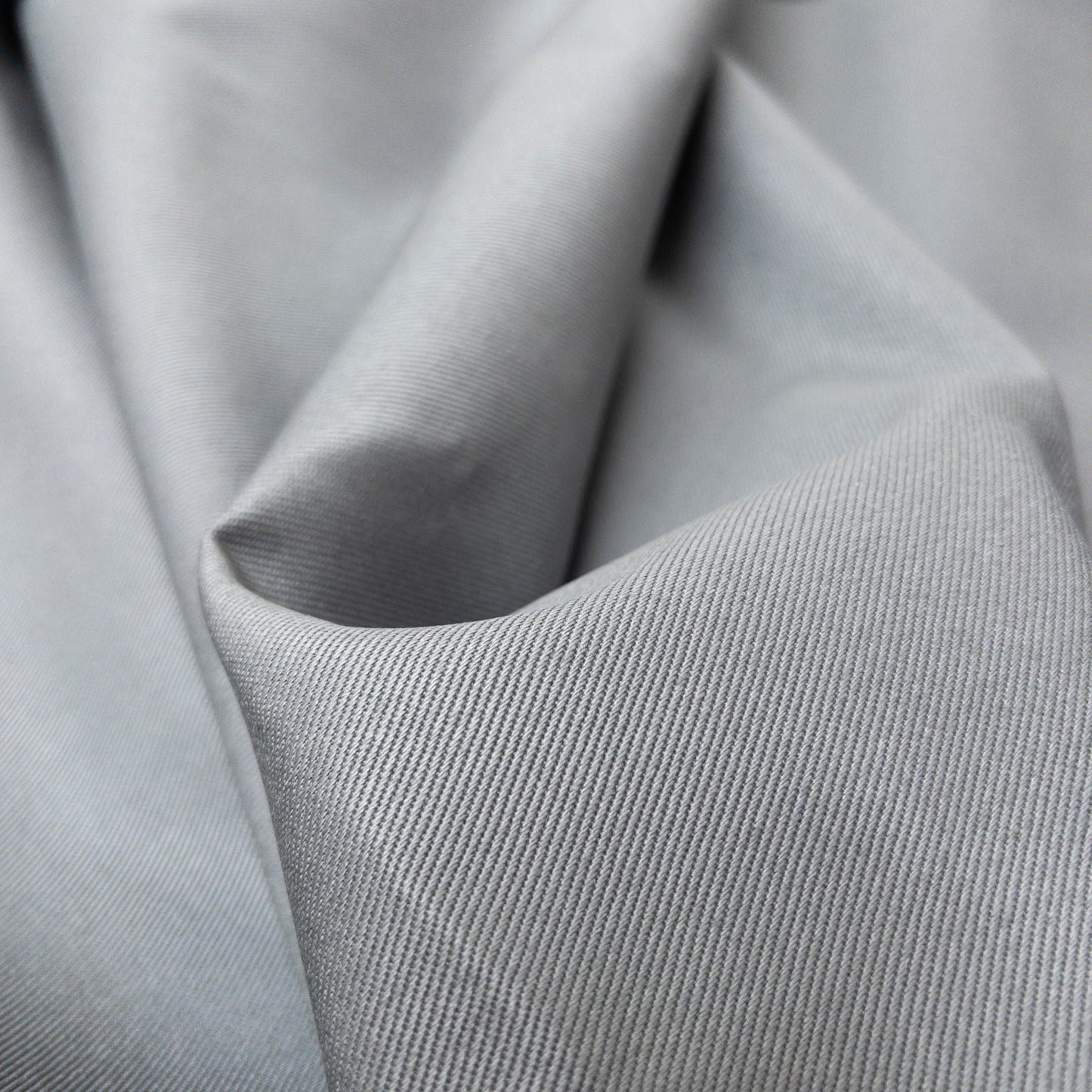 Close up view of heavy twill with deep diagonal ribs in a cool grey