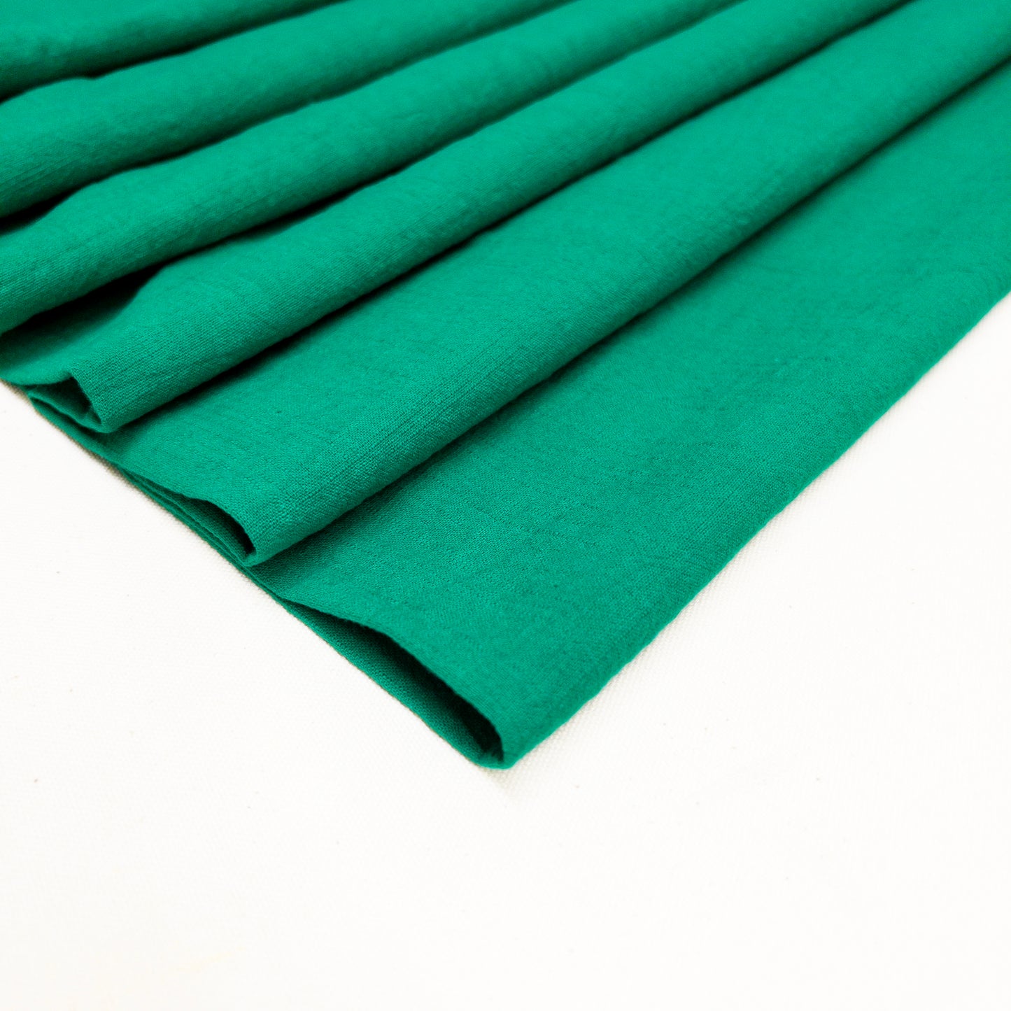 Bright green cotton garment fabric with slub texture folded
