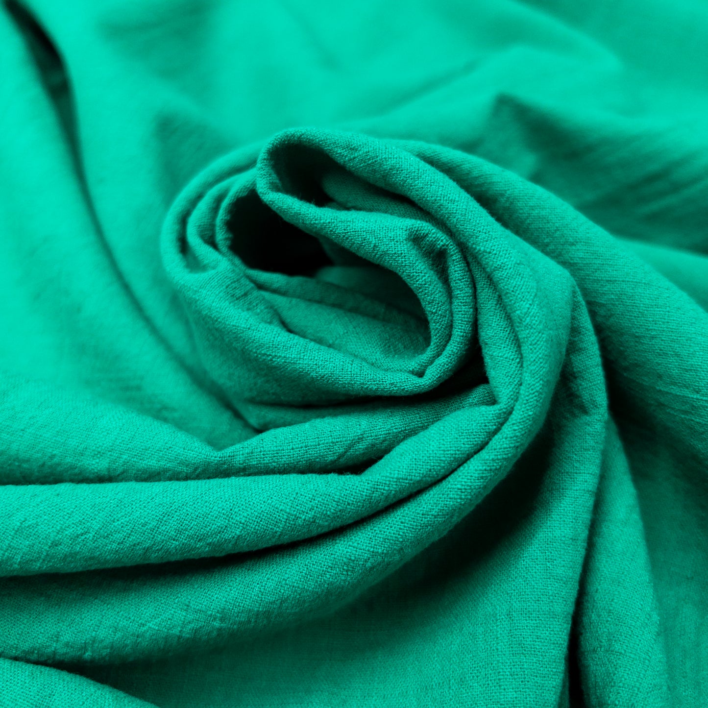 cheerful green cotton fabric with a textured surface arranged as a spiral