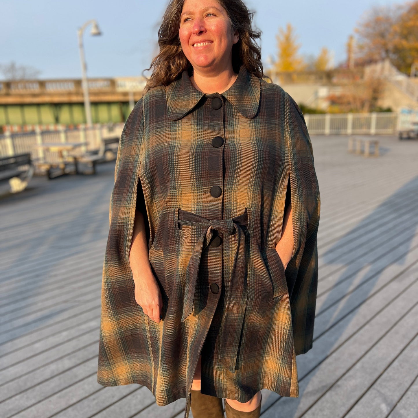 Woman standing in cape of cotton tartan plaid.