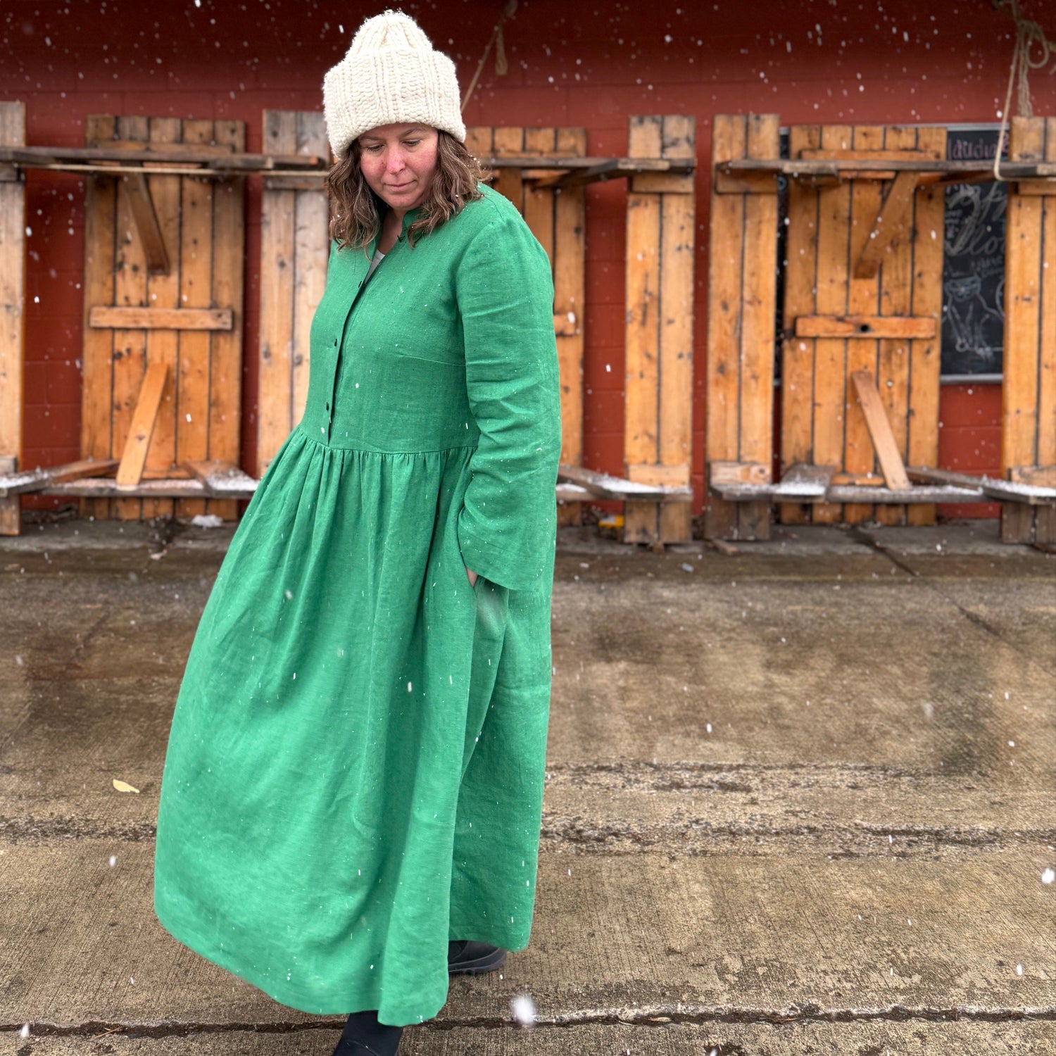 Women in green linen dress made with merchant and mills 185 gsm linen.