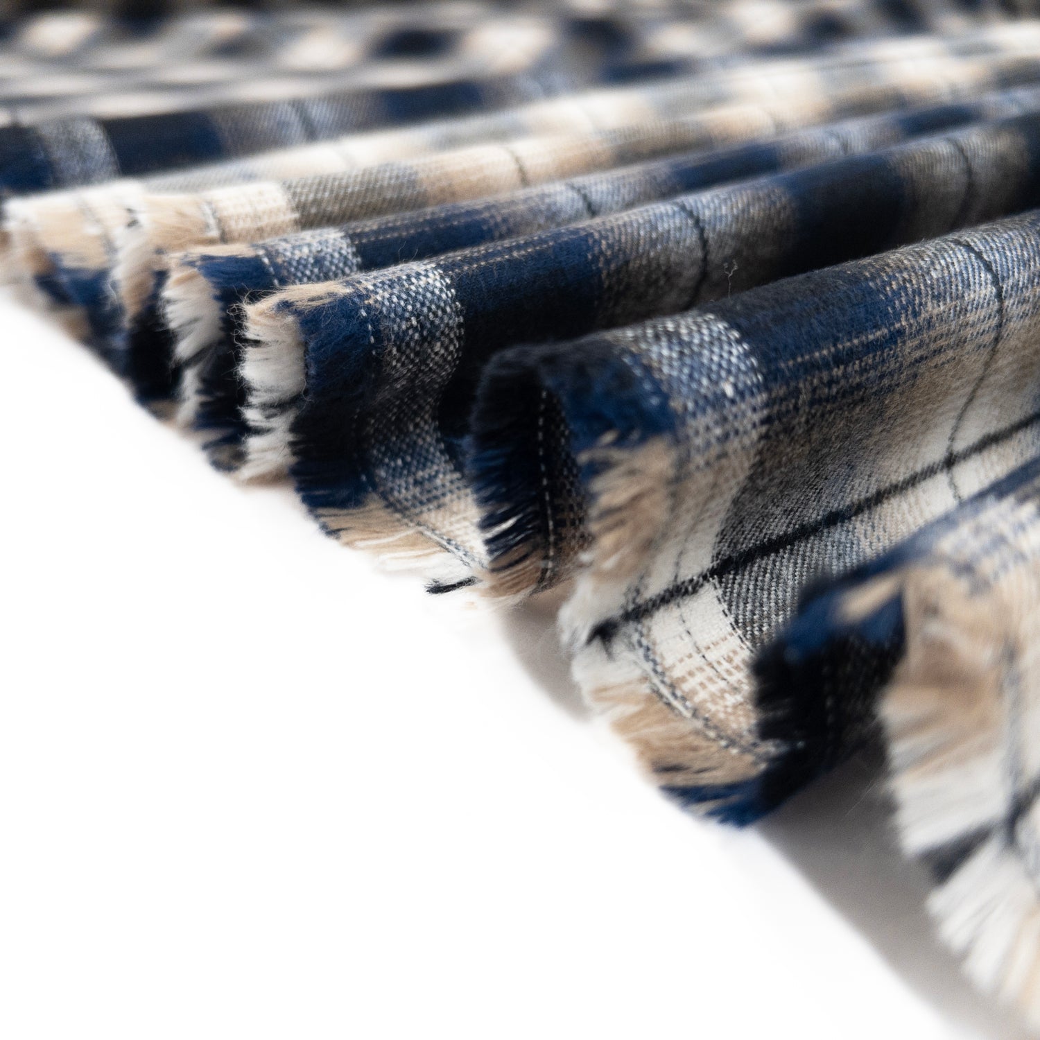 Thick and brushed cotton flannel in blue plaid shown folded in a ribbon.