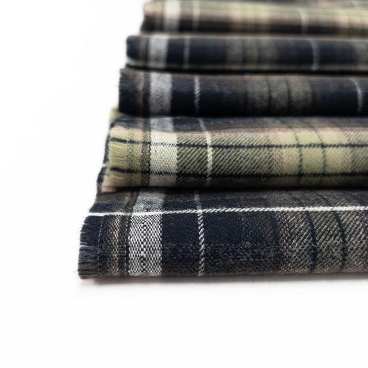 Detail view of quality flannel fabric in green and dark grey with brushed finish.