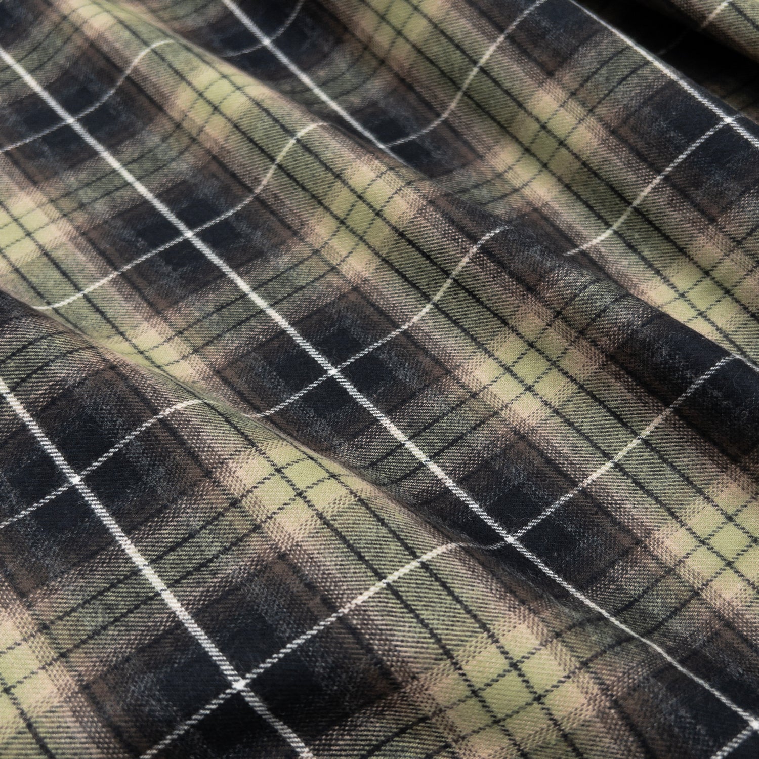 View above of cotton flannel apparel fabric to show green and grey plaid design.