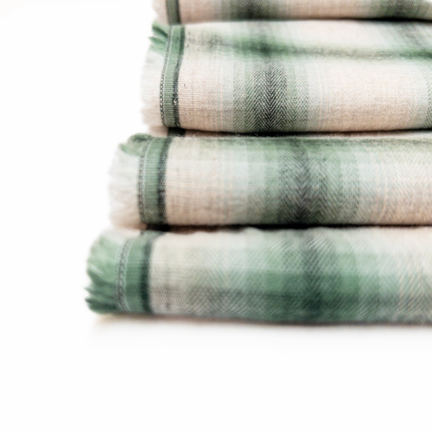 Detail view of the herringbone weave on this 100% cotton shirting apparel fabric in green and natural color