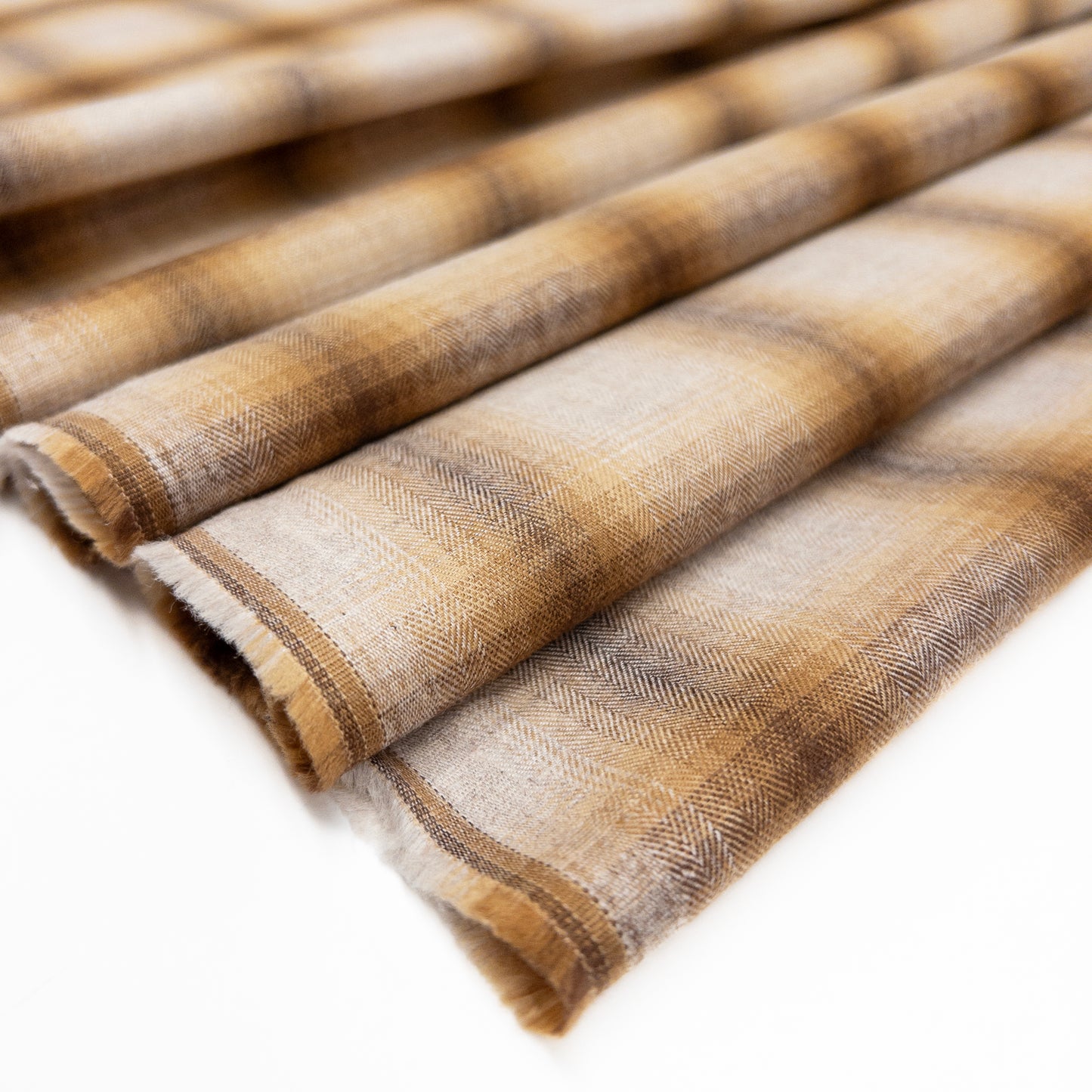 100% cotton shirting fabric featuring a yard dyed grid motif fading from a deep brown to a natural color shown folded