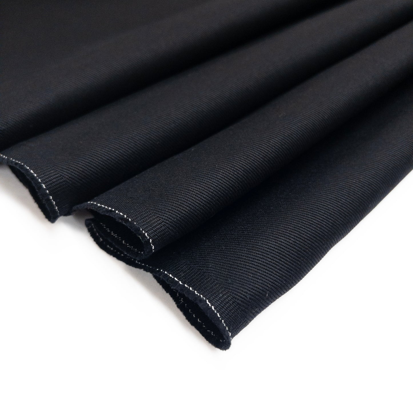 Black cotton twill fabric for clothing shown folded from above.