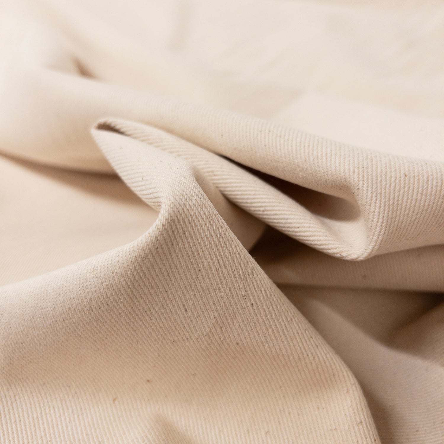 100% cotton twill garment fabric shown folded to illustrate pliable drape