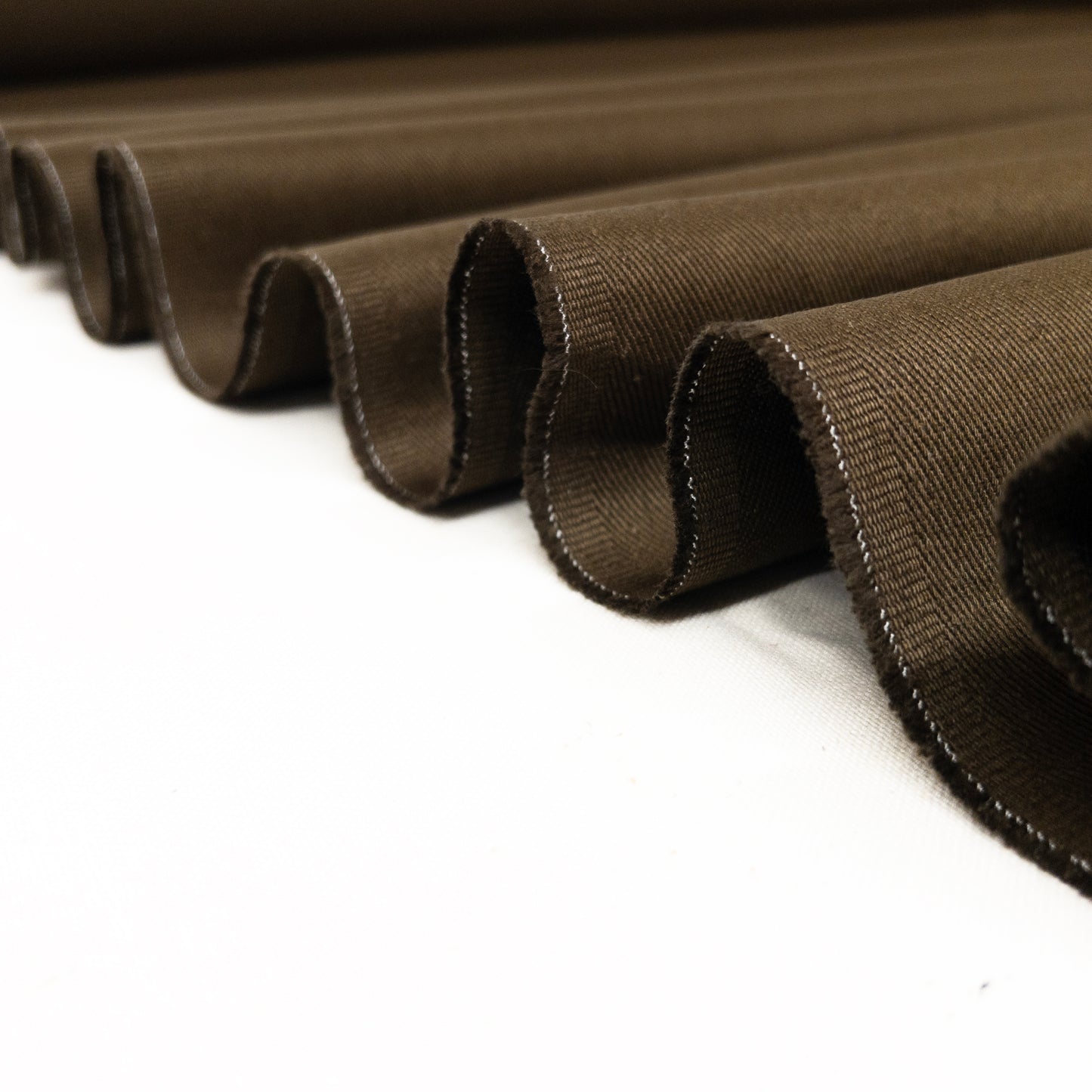 Heavy weight twill garment fabric from 100% cotton in army green folded in a ribbon