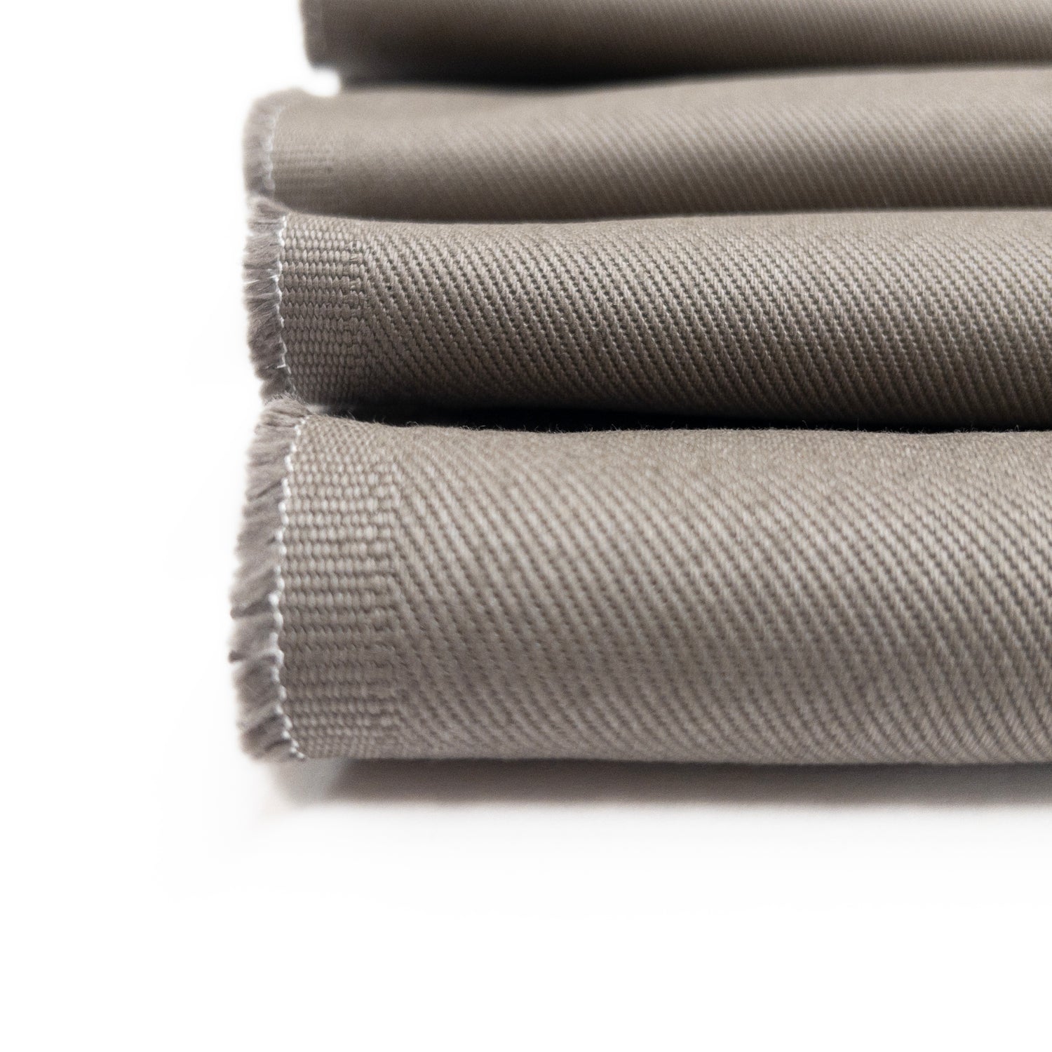 Detail view of bottom weight twill from cotton in a warm grey showing diagonal ribs of fabric face