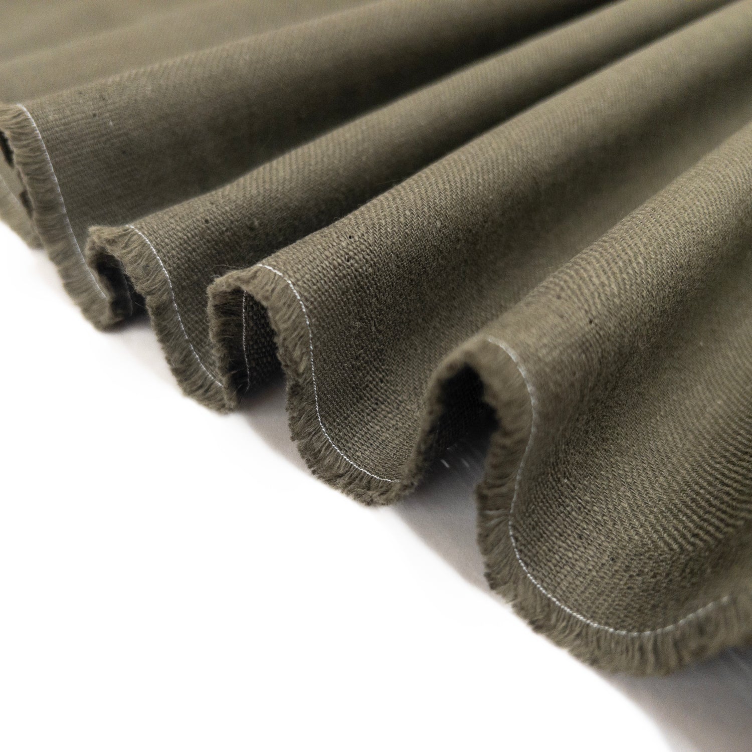 100% cotton apparel fabric folded in a ribbon to show its soft drape.