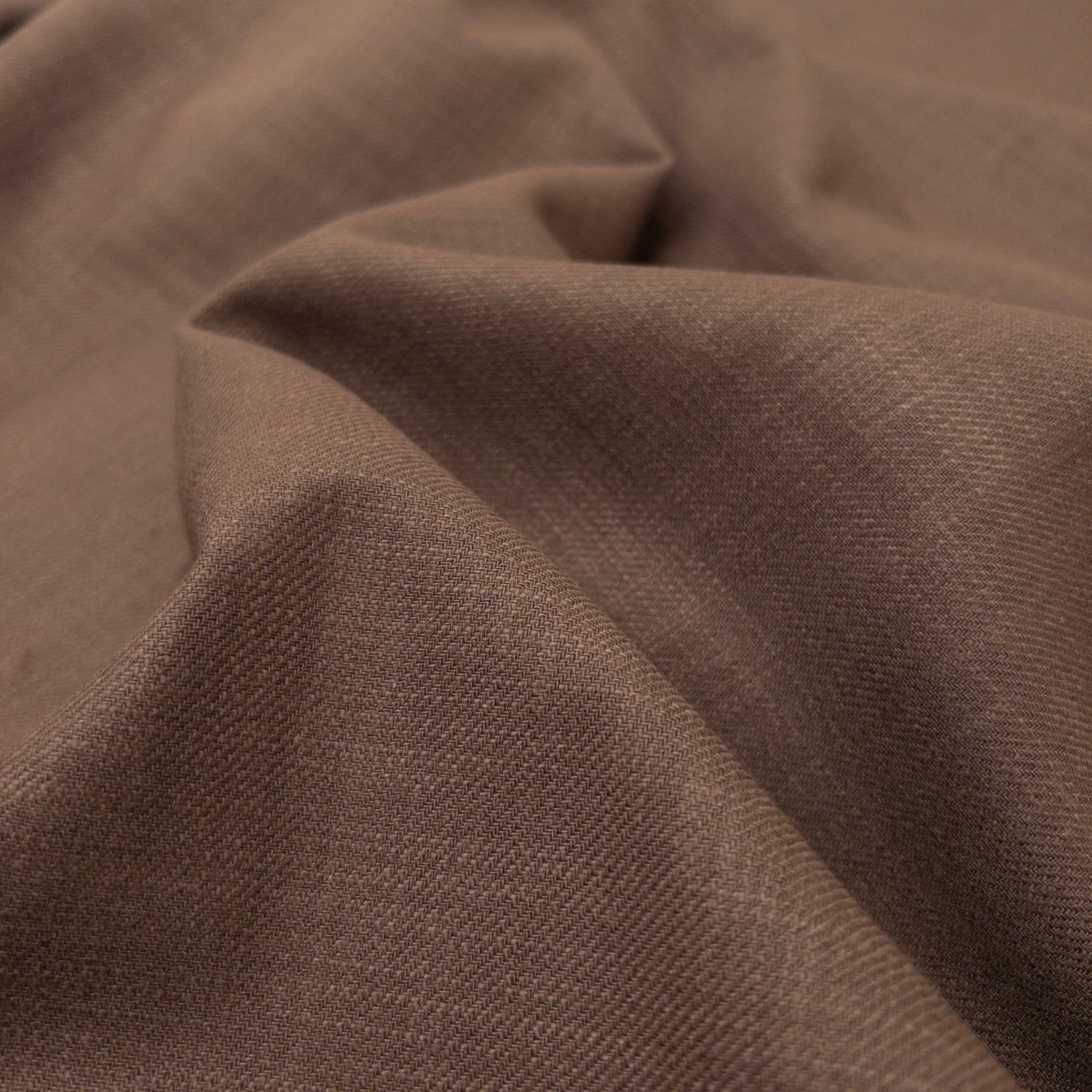 Brown European cotton garment fabric with a textured weave and soft hand seen from above.