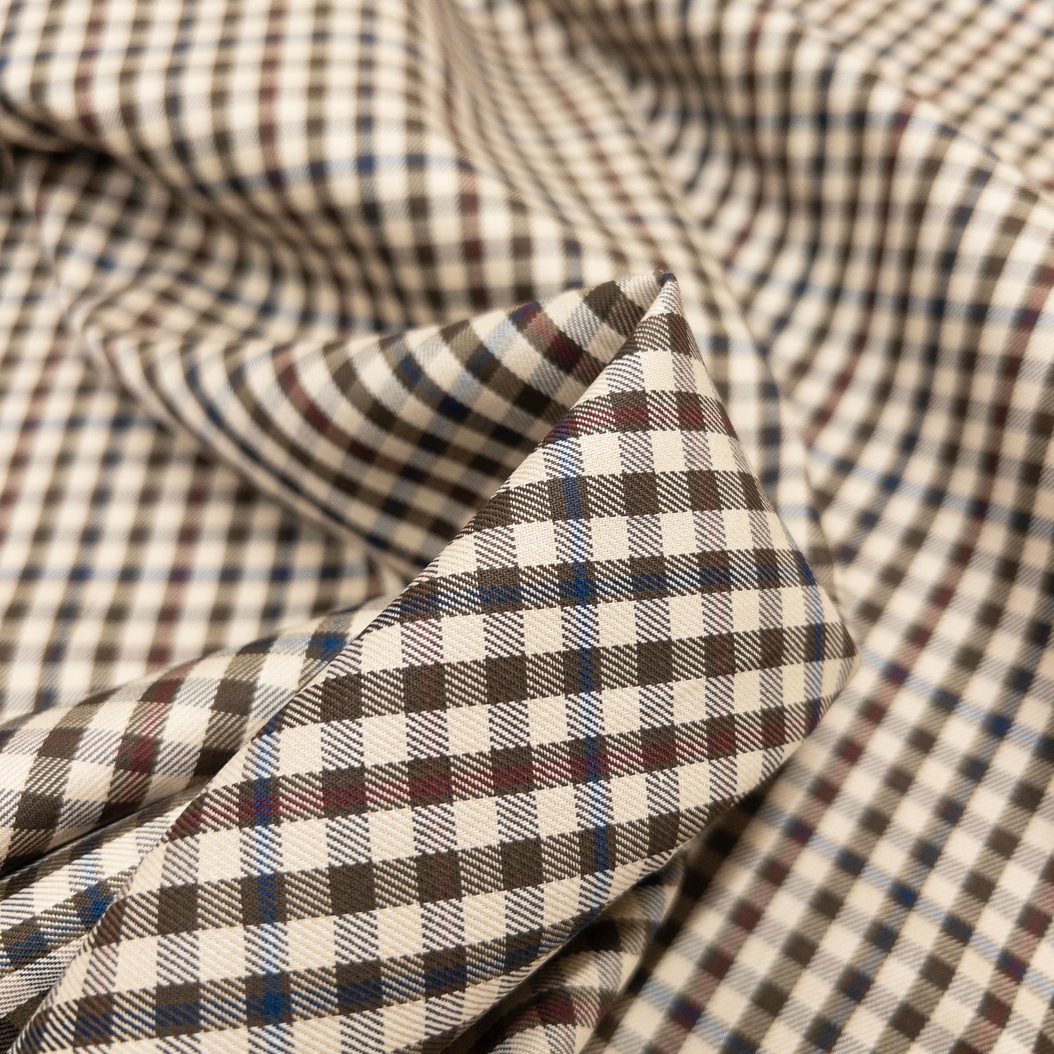 Cotton shirting apparel fabric with a small check pattern.