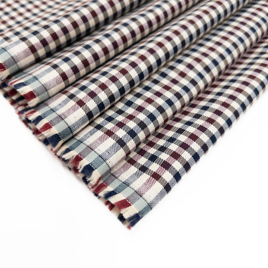 European cotton shirting with a small check in red, white and blue shown folded.