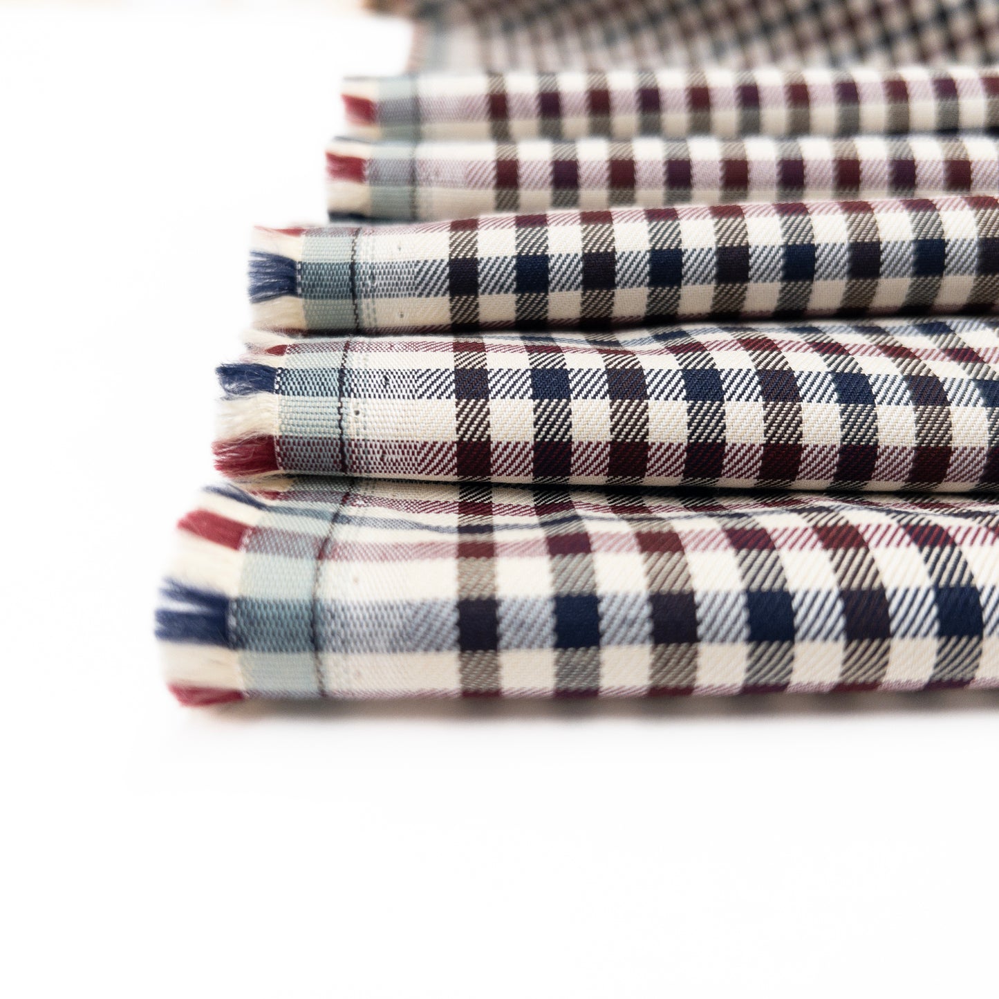 Close up view of 100% cotton garment fabric in a small check pattern.