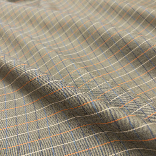 Cotton shirting in olive from above shows design of colored blue and orange grid lines.