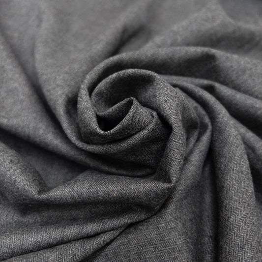 Cotton fabric in dark grey twisted in a spiral.