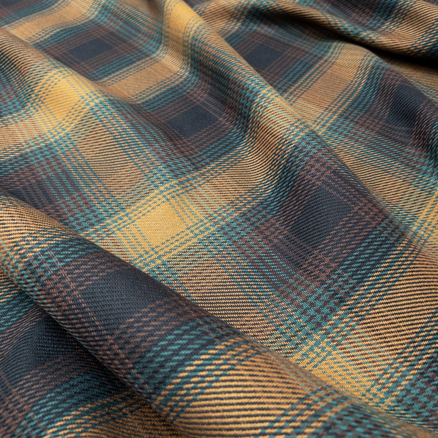 100% organic cotton tartan twill in antique brass shown from above with delicate folds.