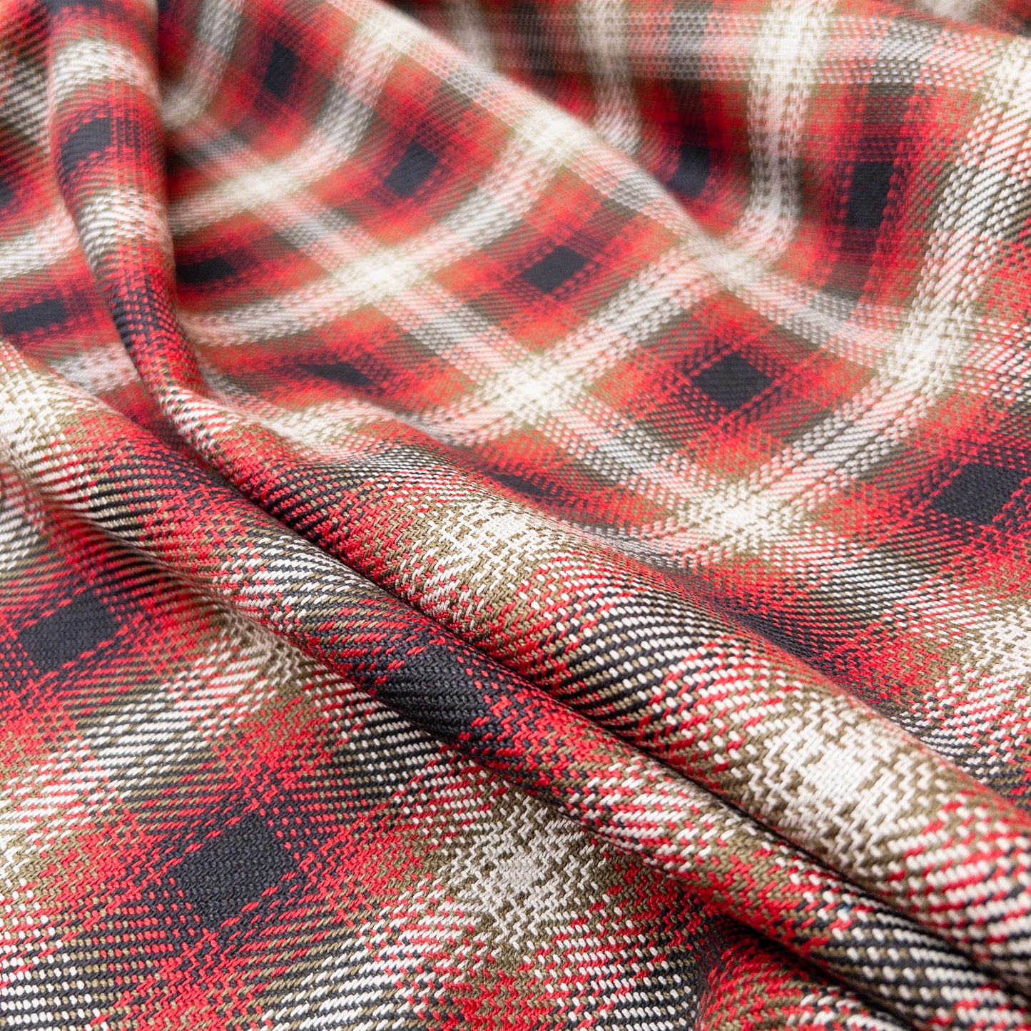 Tartan plaid twill in a red colorway from above to show fabrics soft drape.