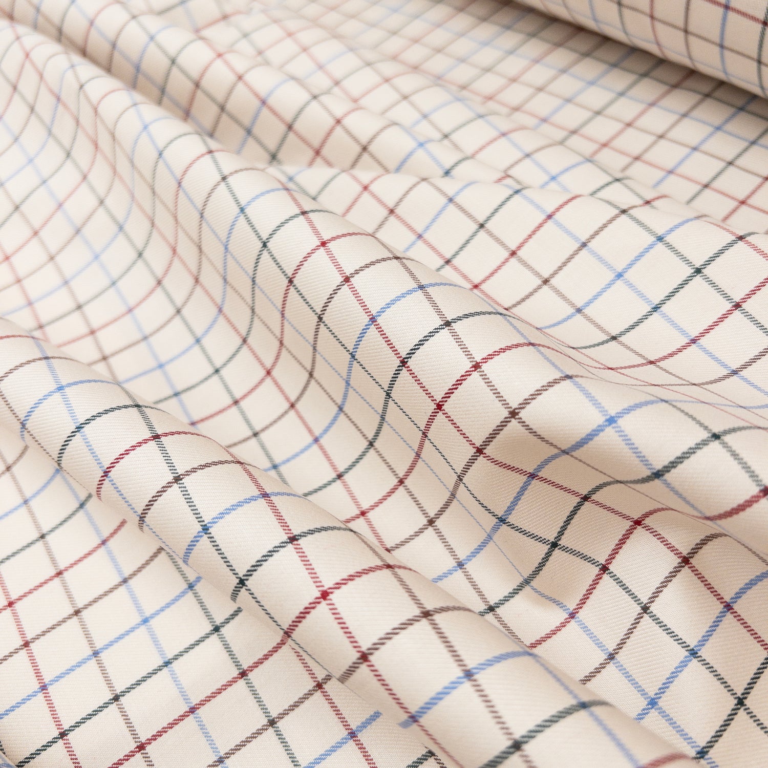 Cotton shirting garment fabric with a twill weave shown from above with folds to demonstrate soft drape.