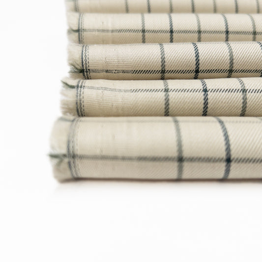 Cotton shirting garment fabric in a twill weave and a tarttesall plaid design shown in a close up view.