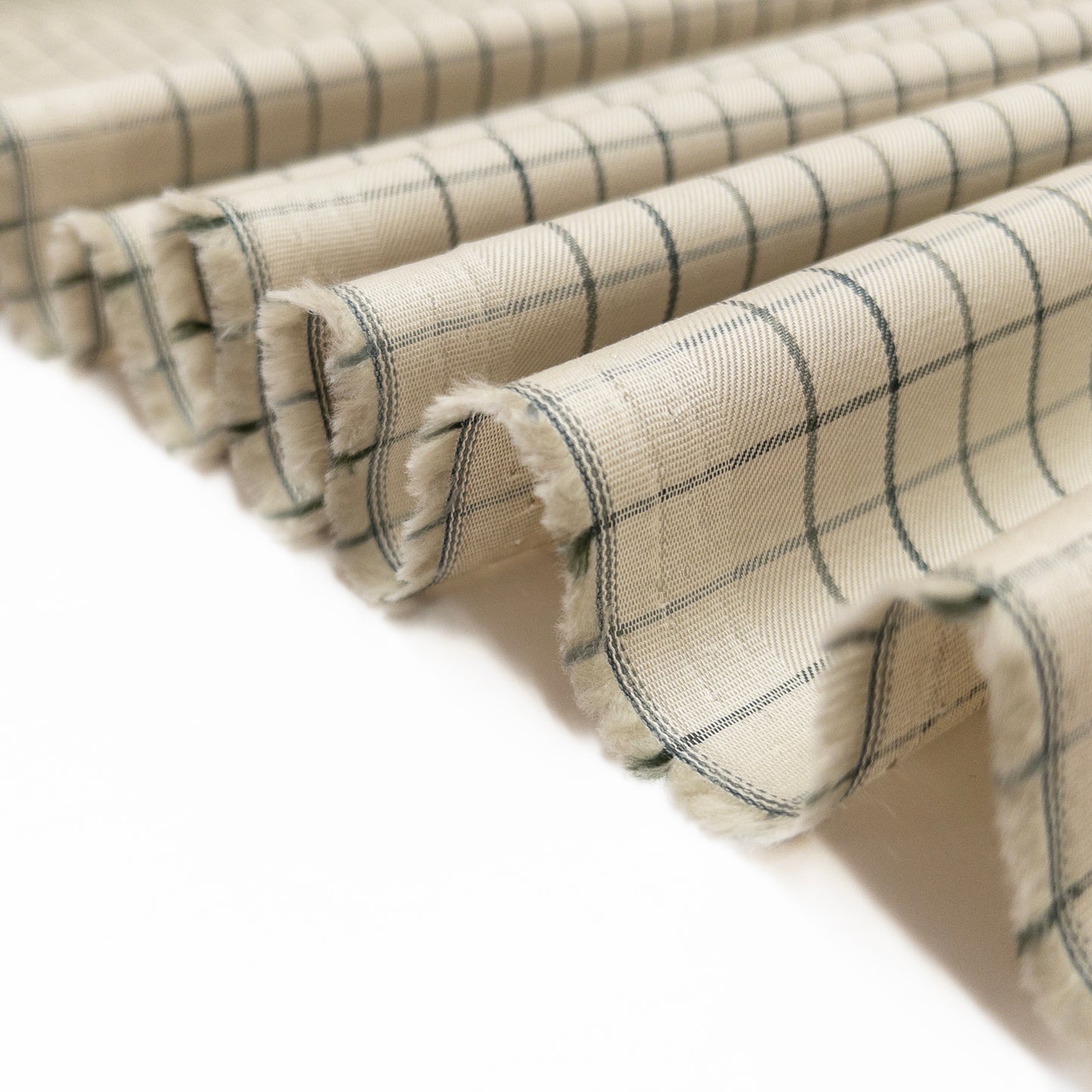 Tattersall plaid shirting cotton folded in a ribbon to show crisp drape of this garment fabric.