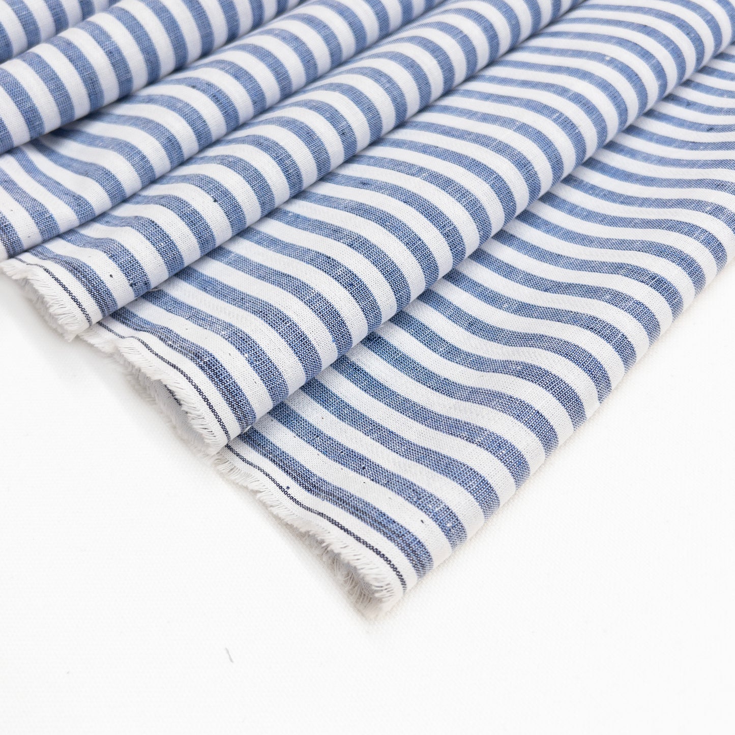 Faded blue and white stripe cotton linen garment fabric shown from above folded over itself.