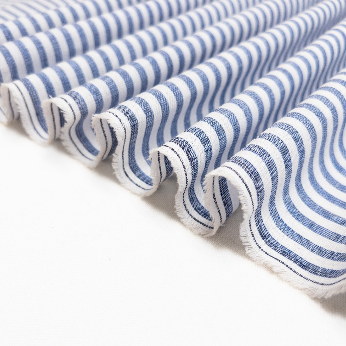 Shown folded in a ribbon this cotton linen garment fabric is lightweight and slightly opaque.