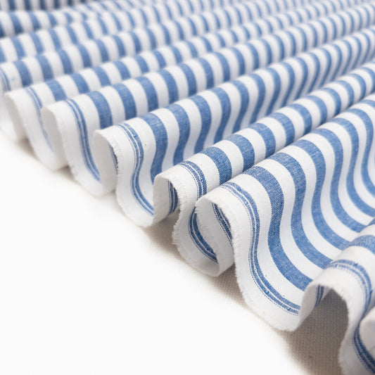 Garment fabric with yarn dyed blue and white stripes shown folded in a ribbon.