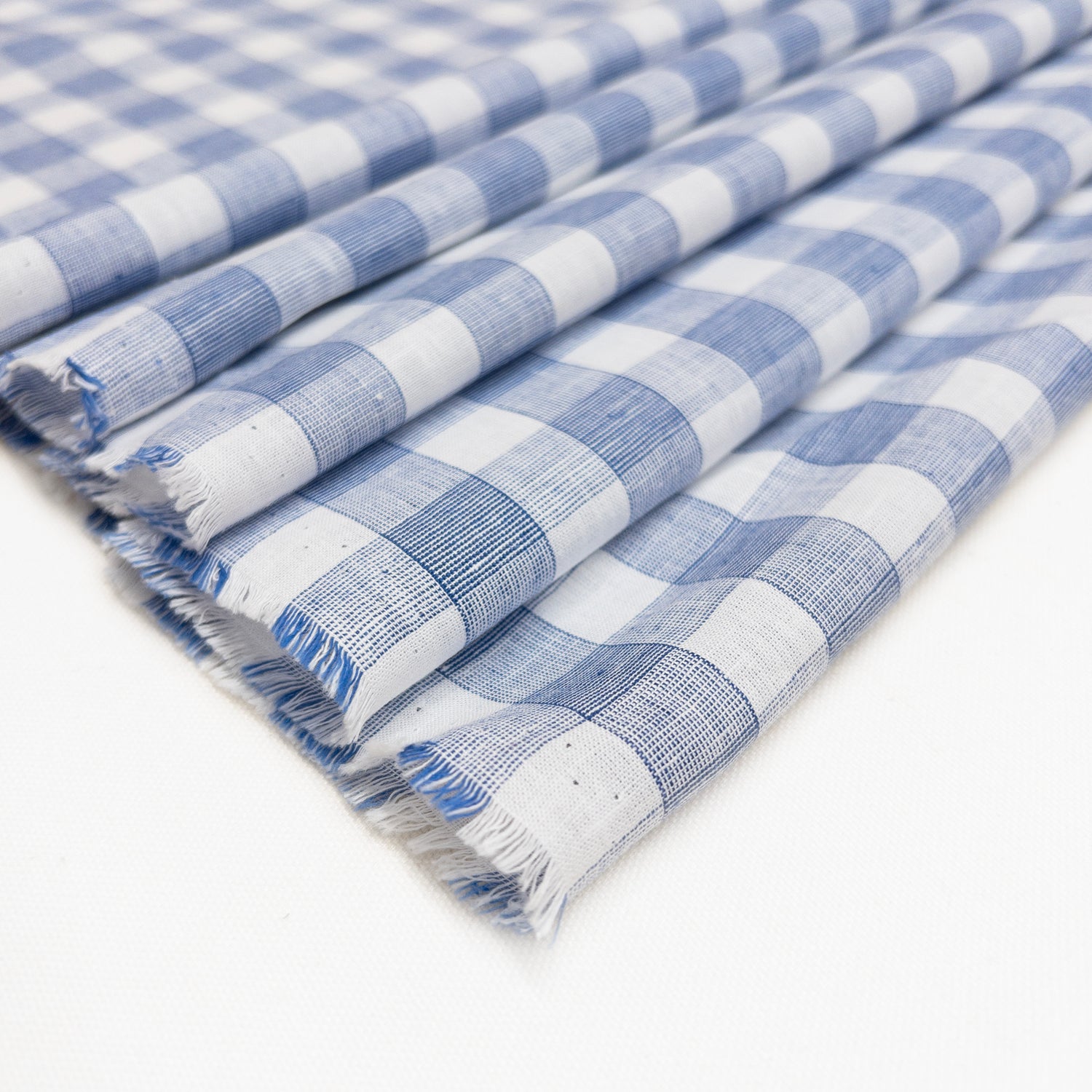 Blue and white very lightweight cotton linen shirting shown folded on itself.