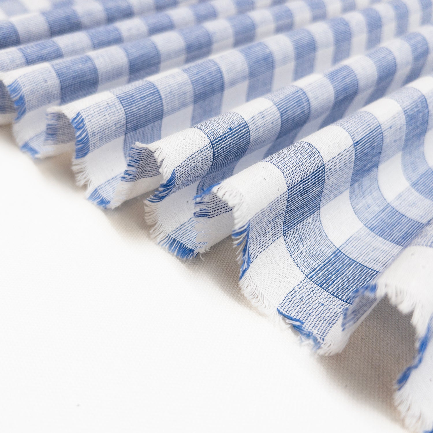 Very lightweight cotton linen apparel fabric folded in a ribbon to demonstrate soft drape.