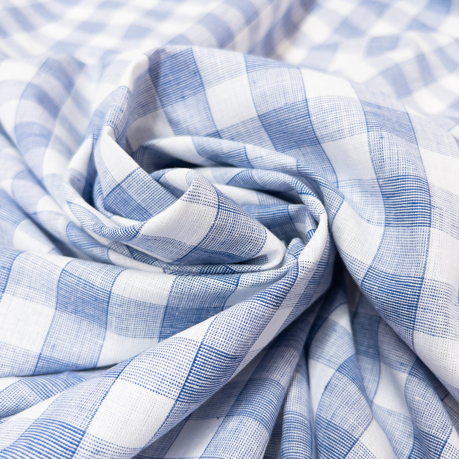 Blue and white check shirting fabric shown spiraled.
