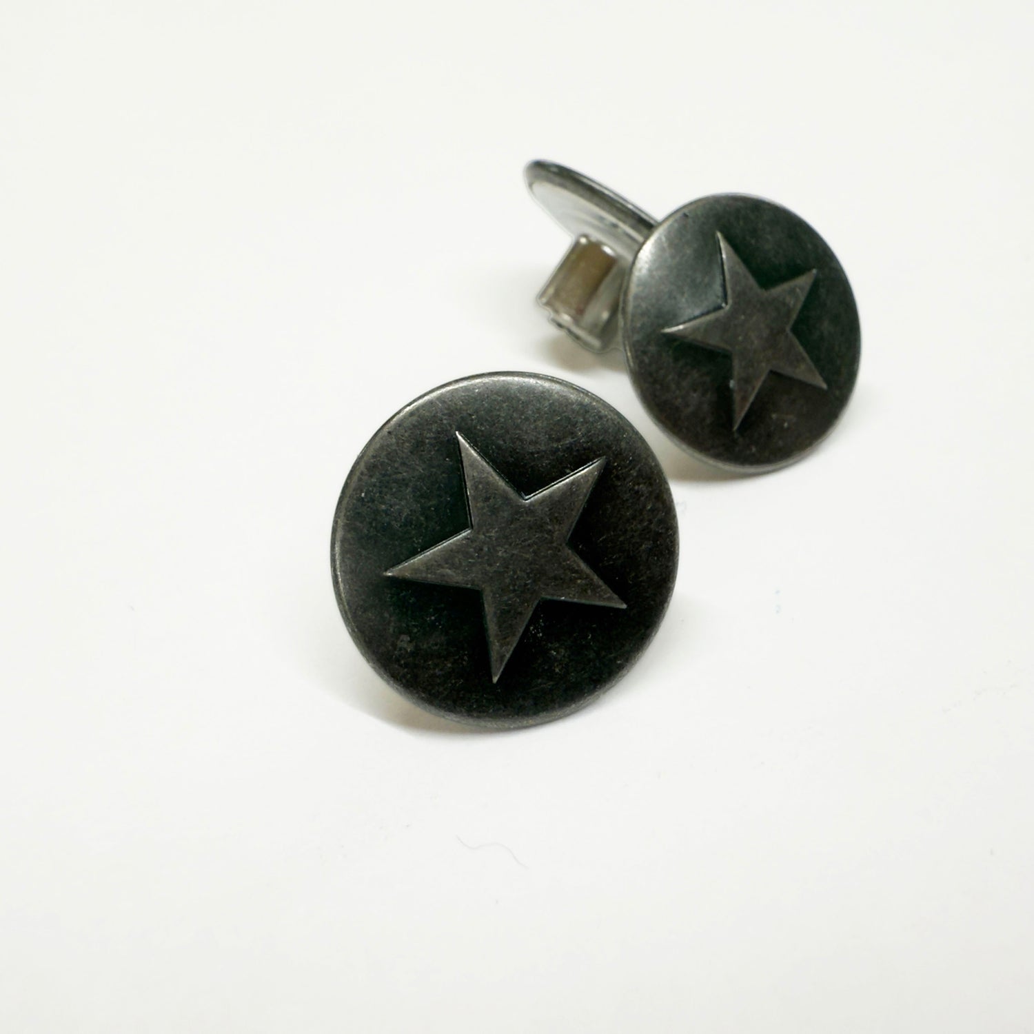 Image of antique silver jeans buttons 18mm in diameter with a single star relief.