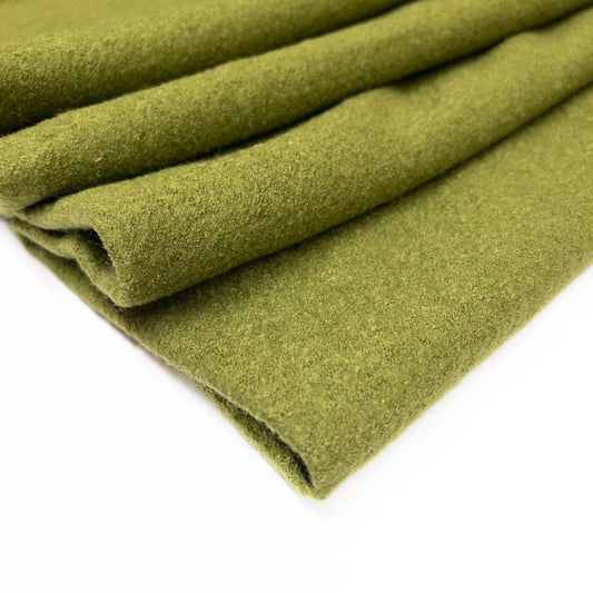 Folded garment fabric of wool and viscose in a bright olive green color.