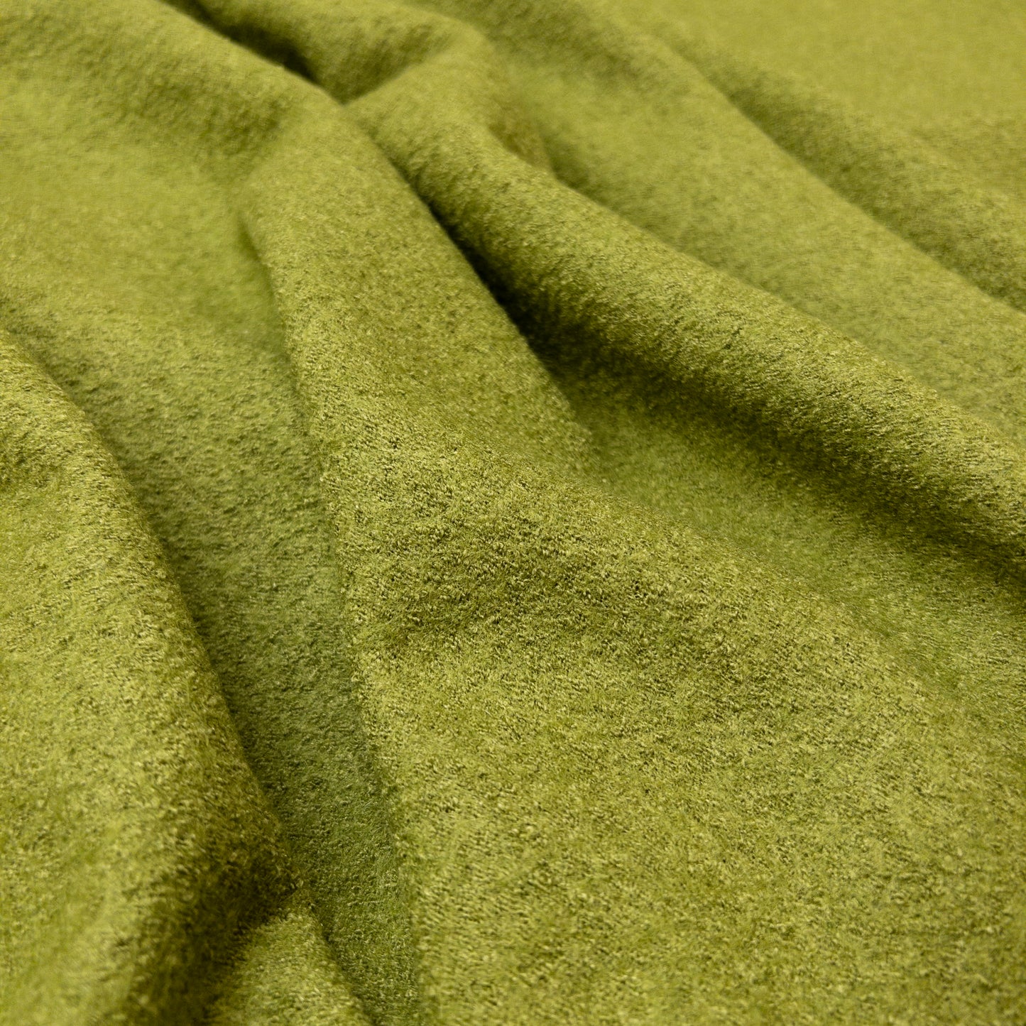 Bright green knit fabric with a textured surface shown from above.