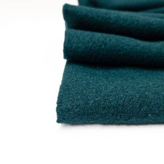 blue green boiled wool and viscose apparel fabric in a close up view to show fabric teture.