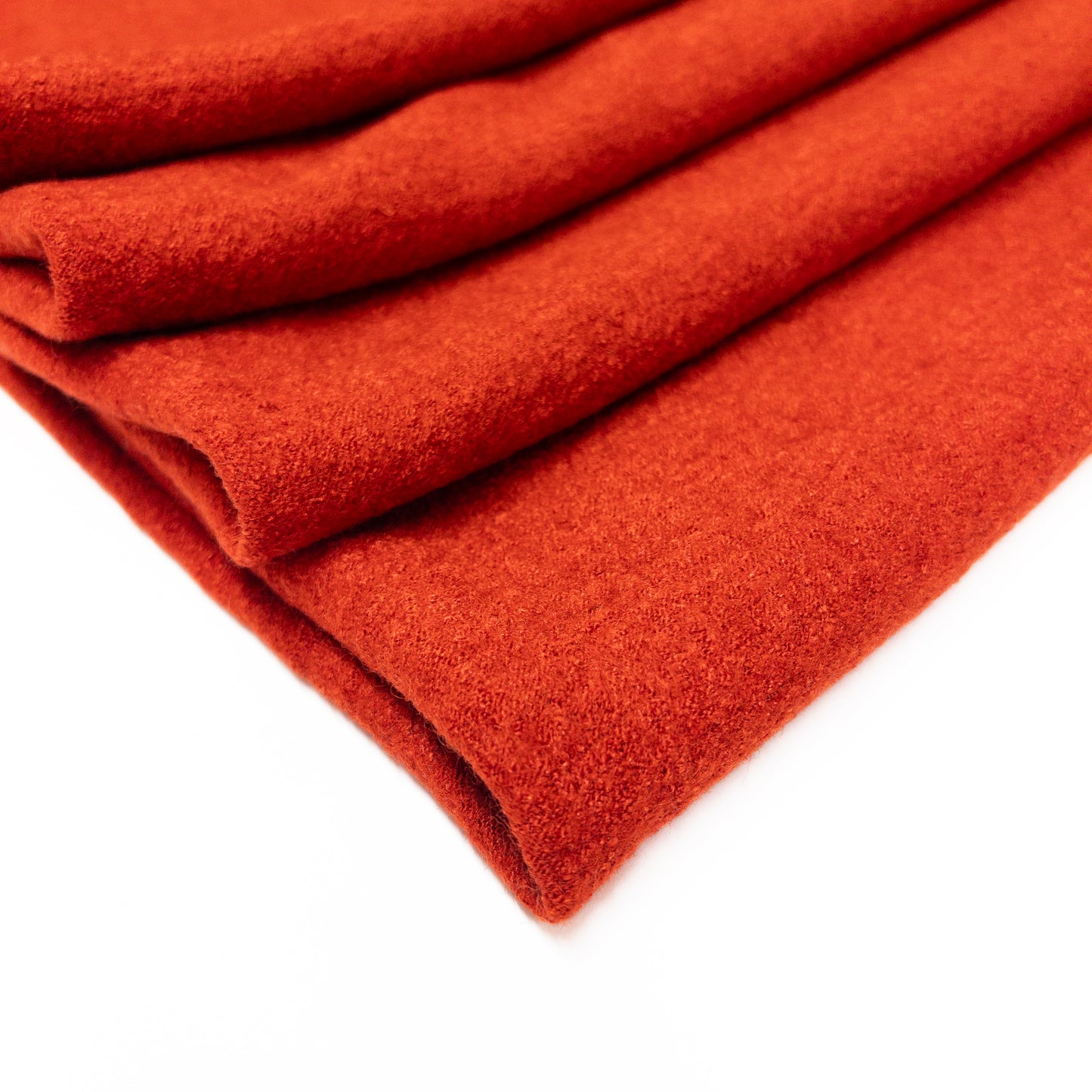 Pumpkin spice boiled wool and viscose garment fabric shown folded.