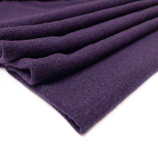 Boiled wool and viscose apparel fabric is deep purple shown folded.