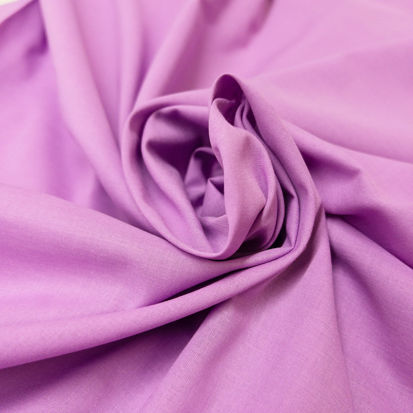 Amethyst cotton voild fabric shown swirled indicating how the fabric is able to hold its shape