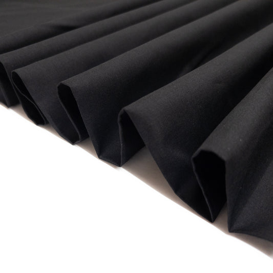 Black cotton voile shown folded as a ribbon to demonstrate fabric stiffness and structure