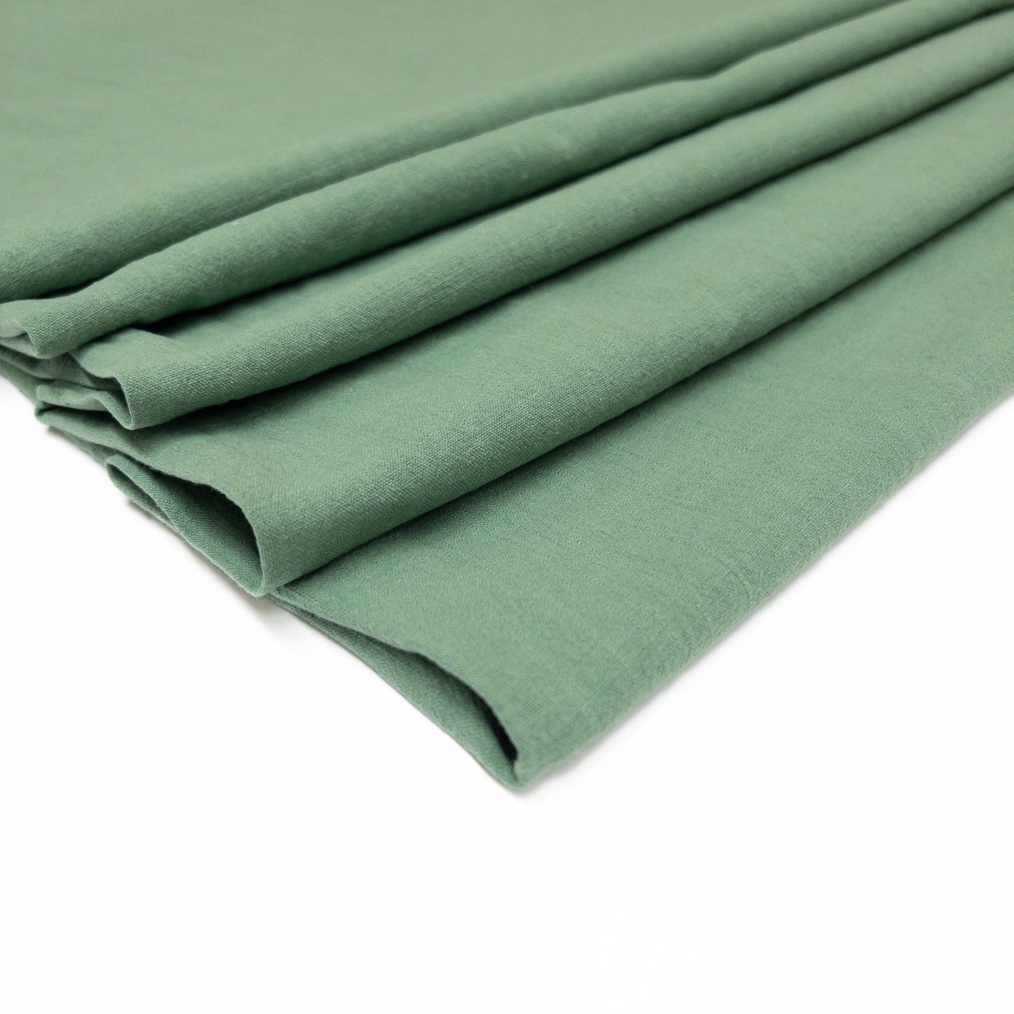 Lightweight dark sage cotton garment fabric folded in layers