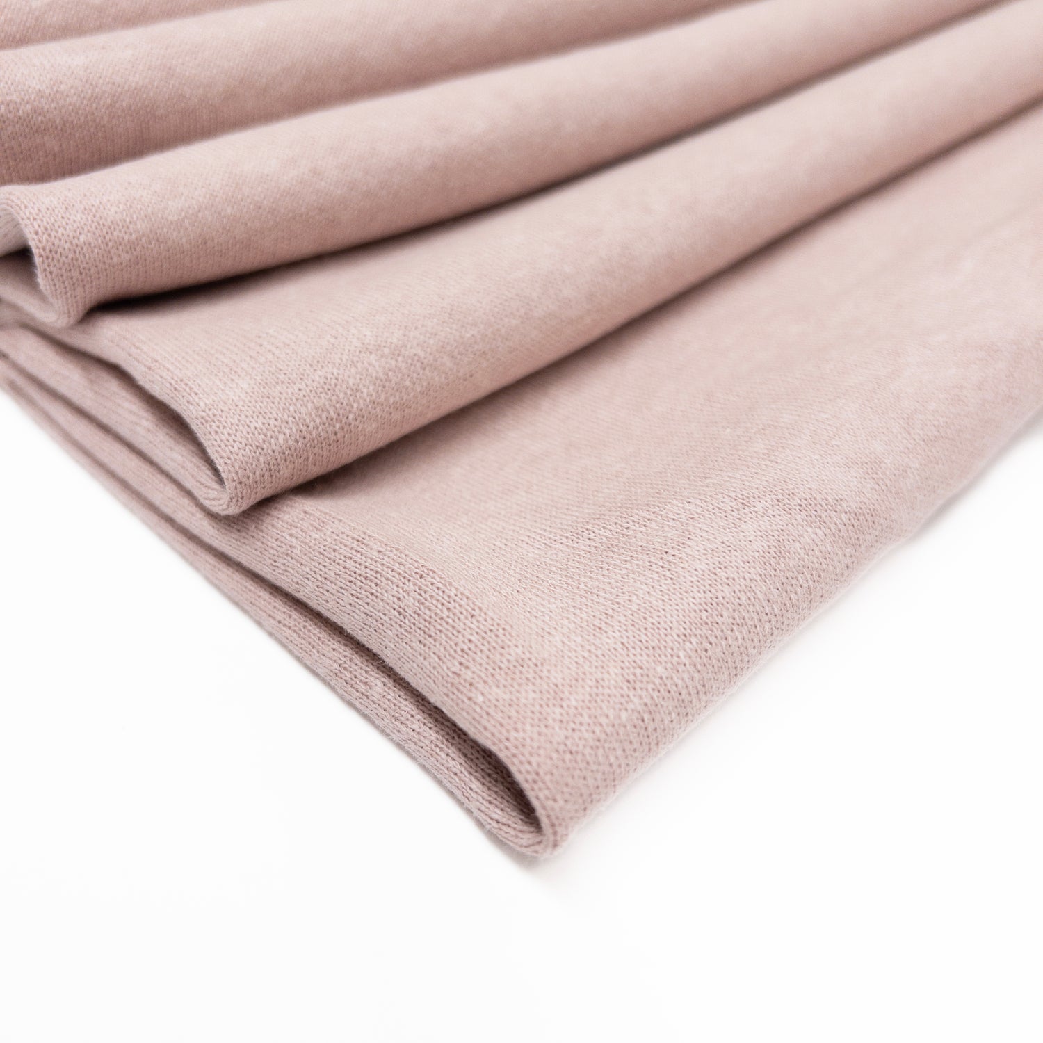 Fleece back knit fabric in a pale blush of organic cotton, hemp and bamboo sown folded.