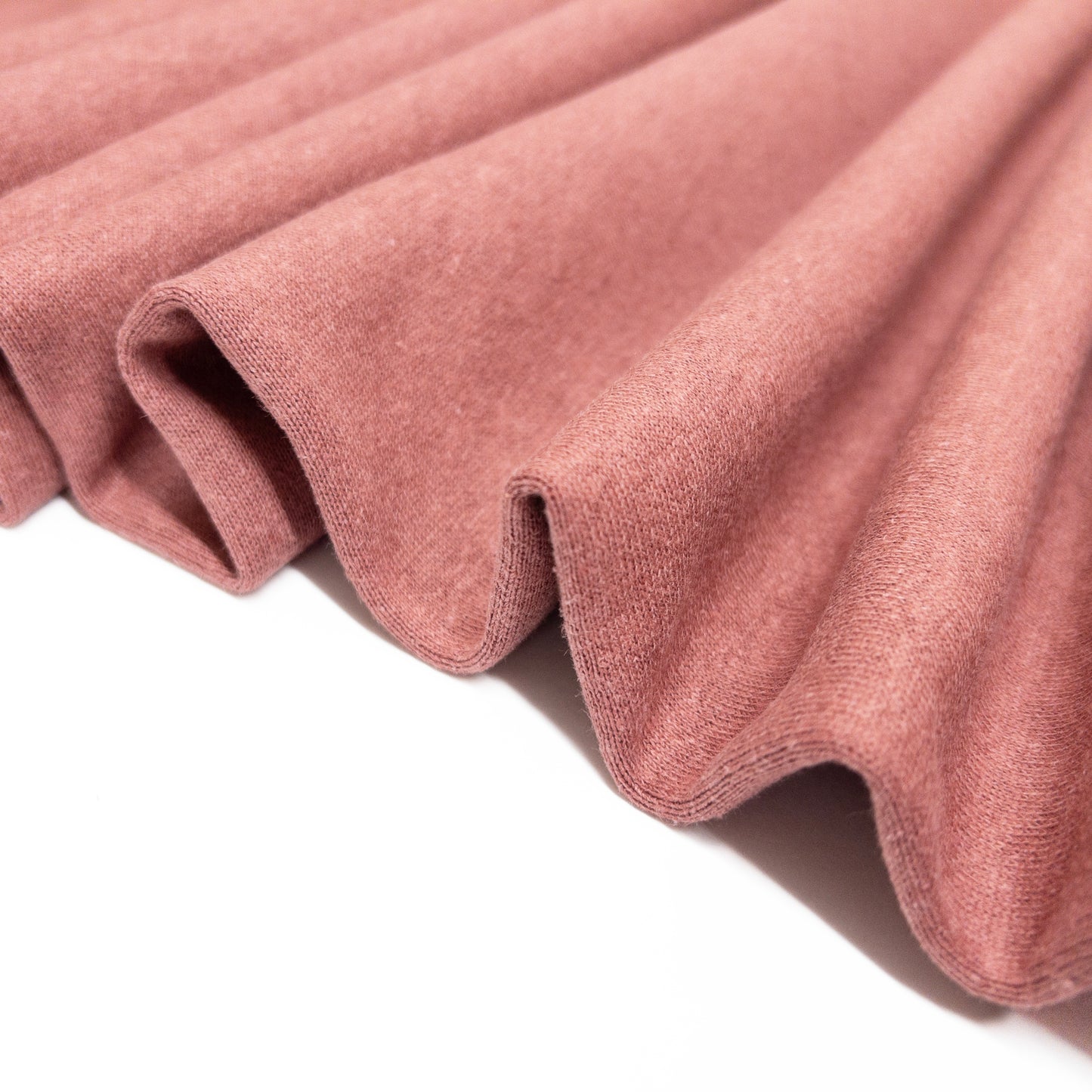 Organic cotton fleece folded in a ribbon to show fabric stability.