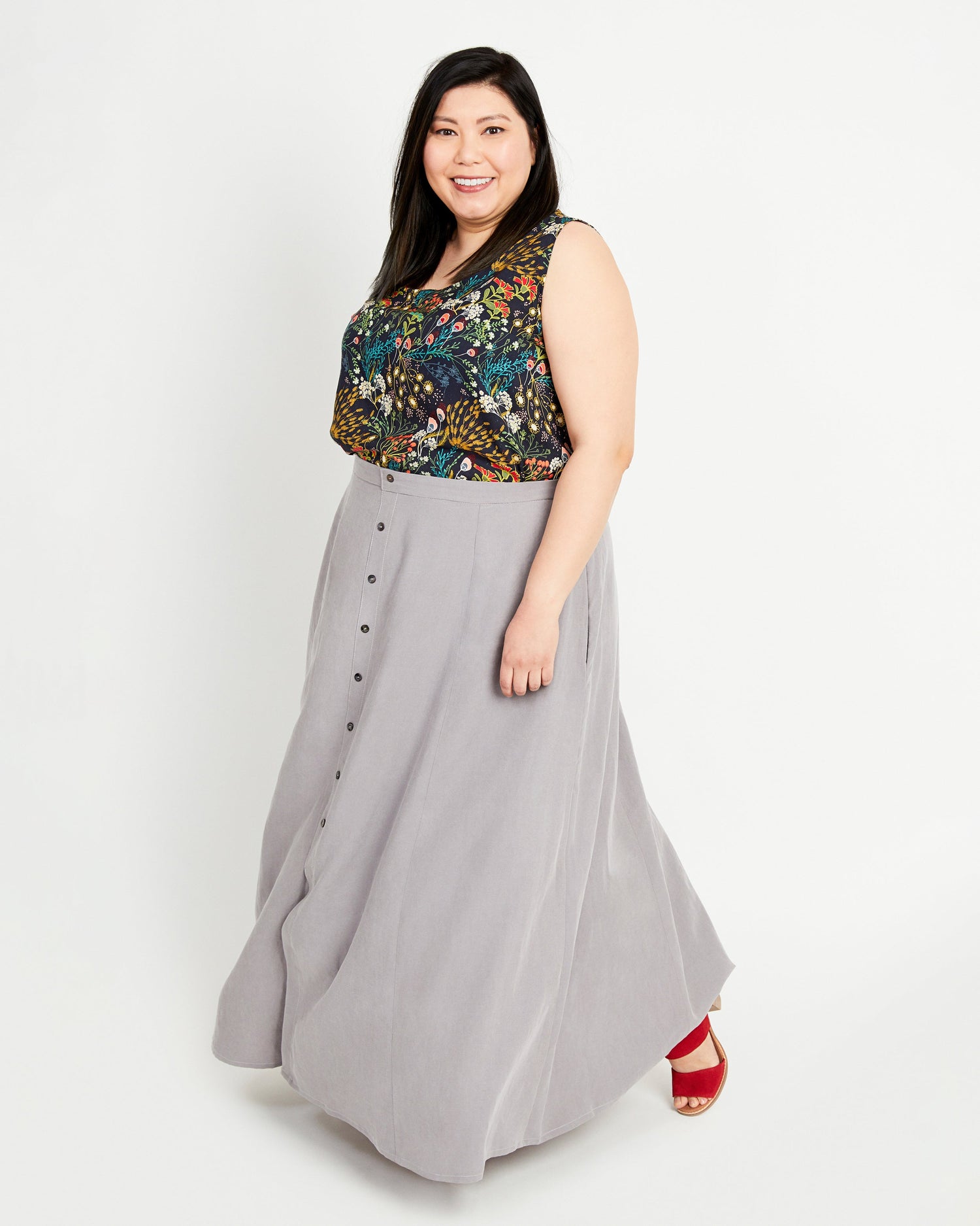 Woman wearing a floral top and gray skirt on a white background. This is the Holyoke Maxi Dress & Skirt sewing pattern from Cashmerette.