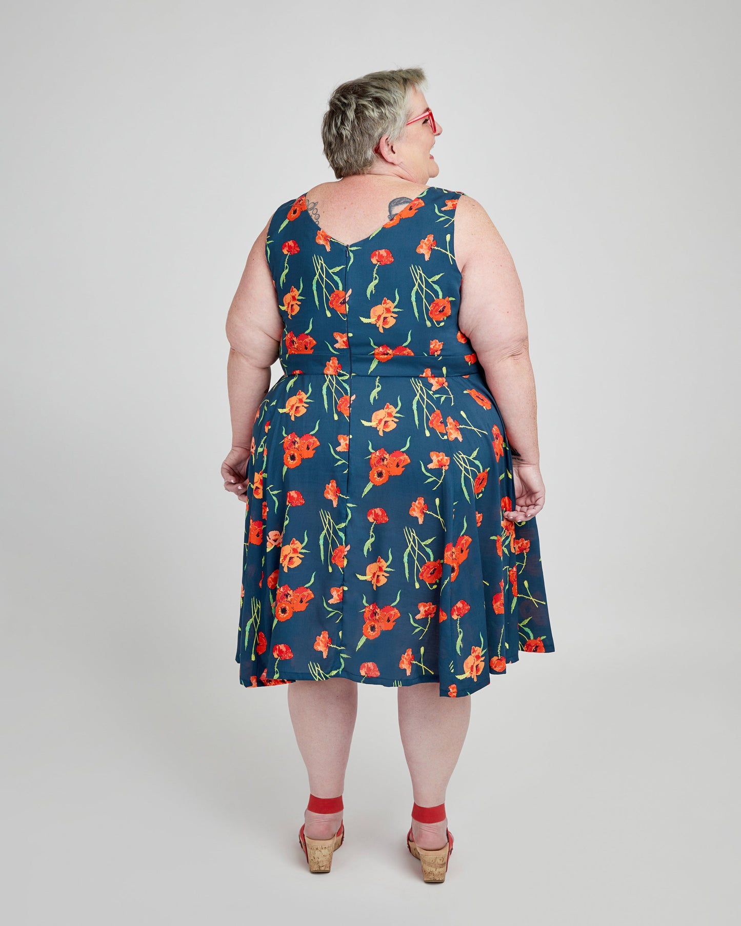 Woman wearing a blue floral dress on a white background. This dress is the Upton Dress & Skirt sewing pattern from Cashmerette.
