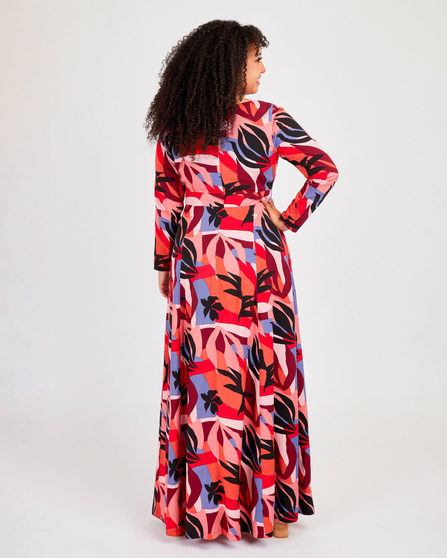 Woman wearing a colorful patterned dress on a white background. This dress is the Upton Dress & Skirt sewing pattern from Cashmerette.
