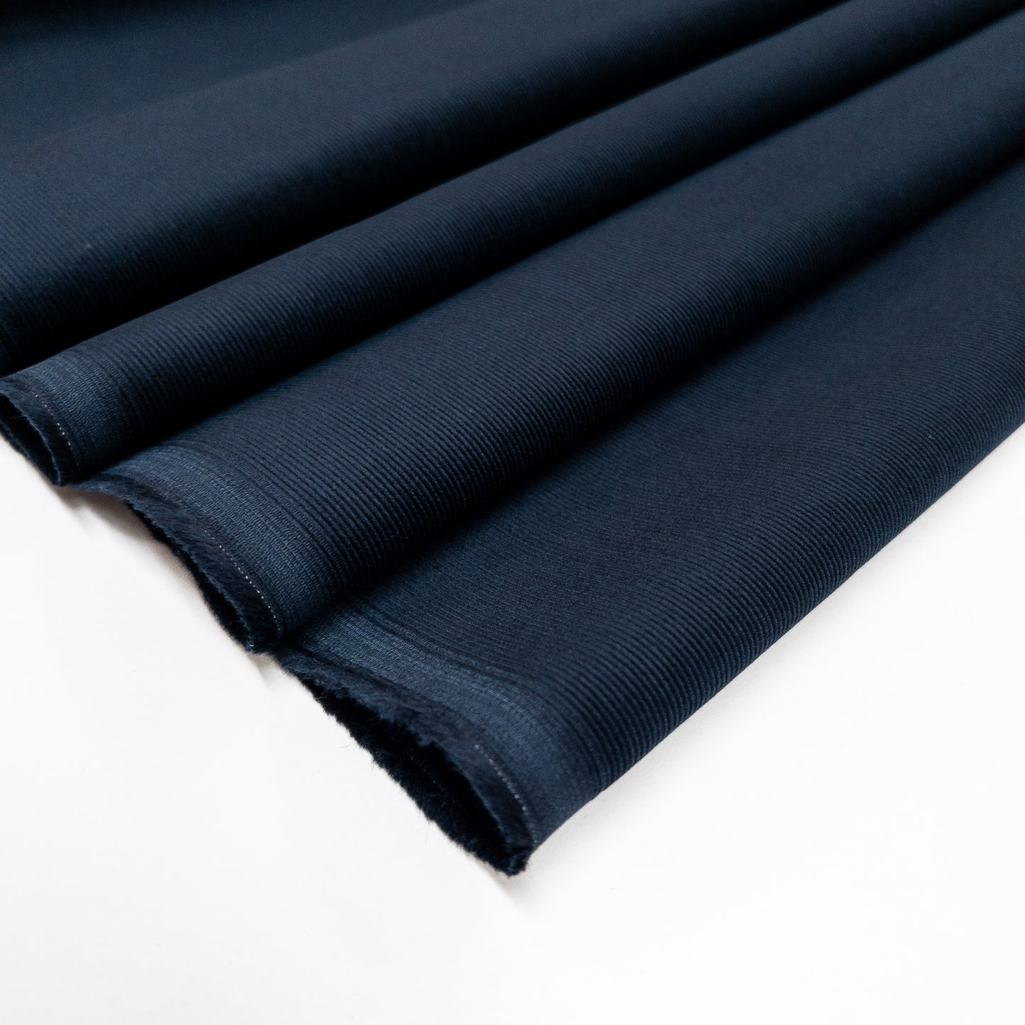 Organic cotton baby corduroy garment fabric in a dark blue shown folded