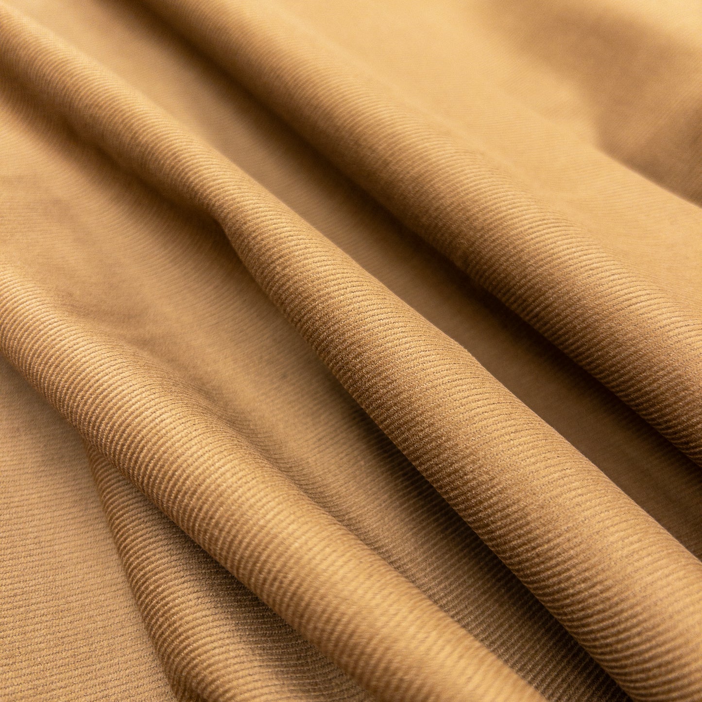 Face view of organic cotton garment fabric with slight folds illustrates small ribs of baby corduroy