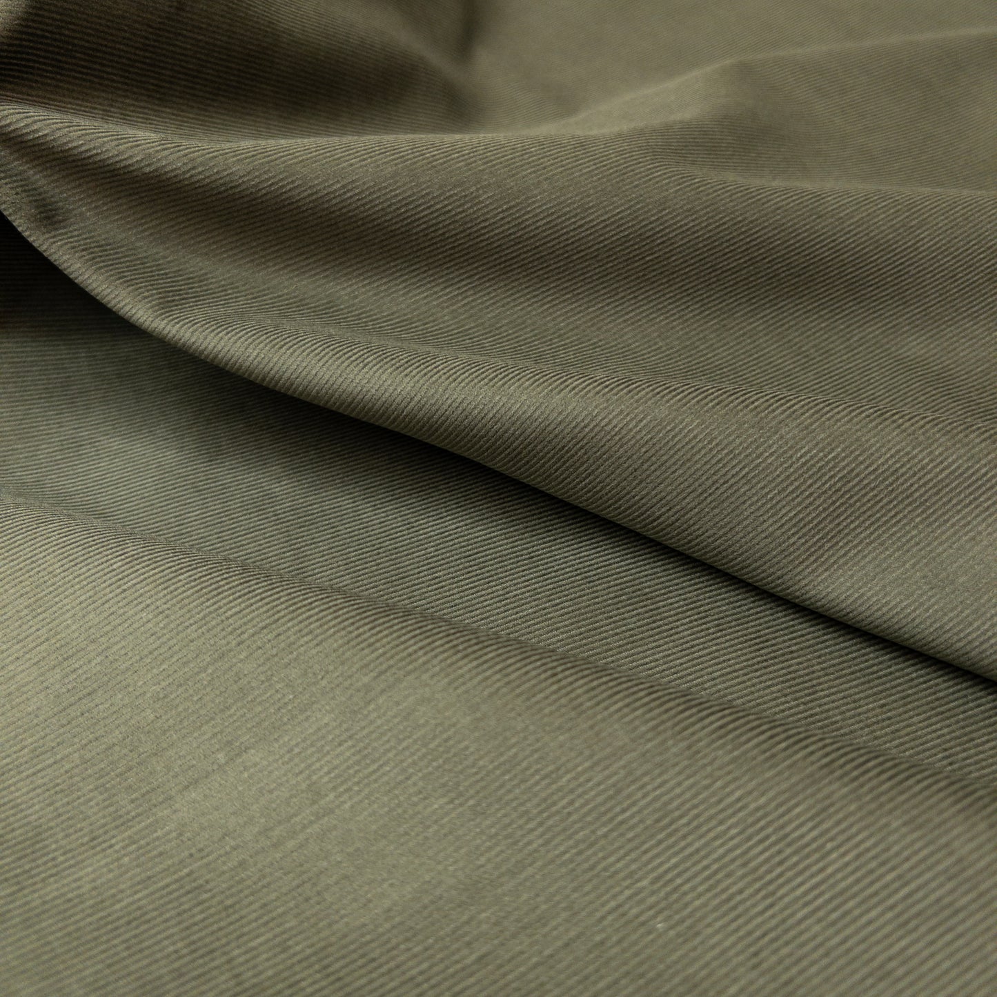 Face view of 100% organic cotton baby corduroy in green with slight folds illustrates fabric sheen